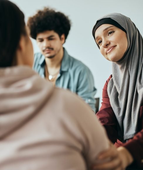 muslim-woman-encouraging-female-friend-to-talk-about-mental-health-problems-during-group-therapy-